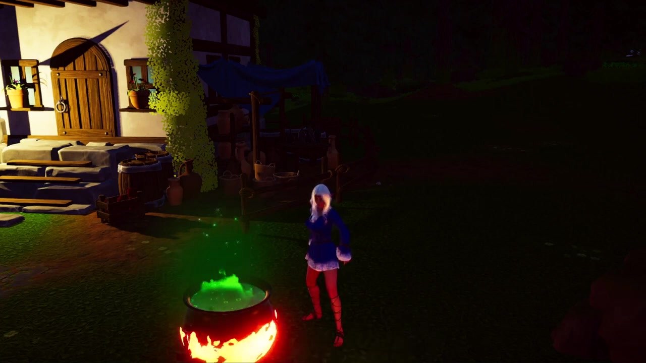 A glowing cauldron outside a cottage at night
